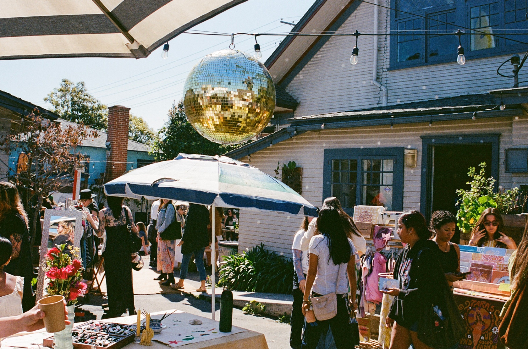 Disco ball above a sunlit outdoor market