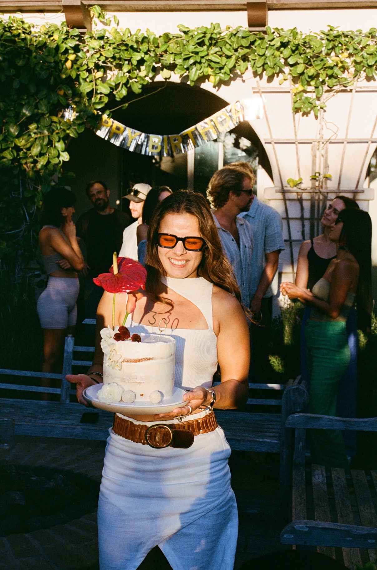 Holding a birthday cake in warm afternoon light
