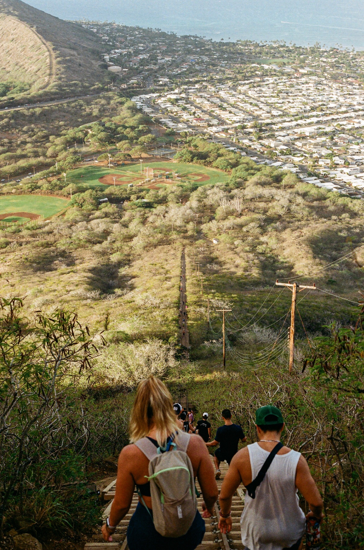 Hikers descending the Koko Head railway stairs with sweeping views of Hawaii Kai and the ocean