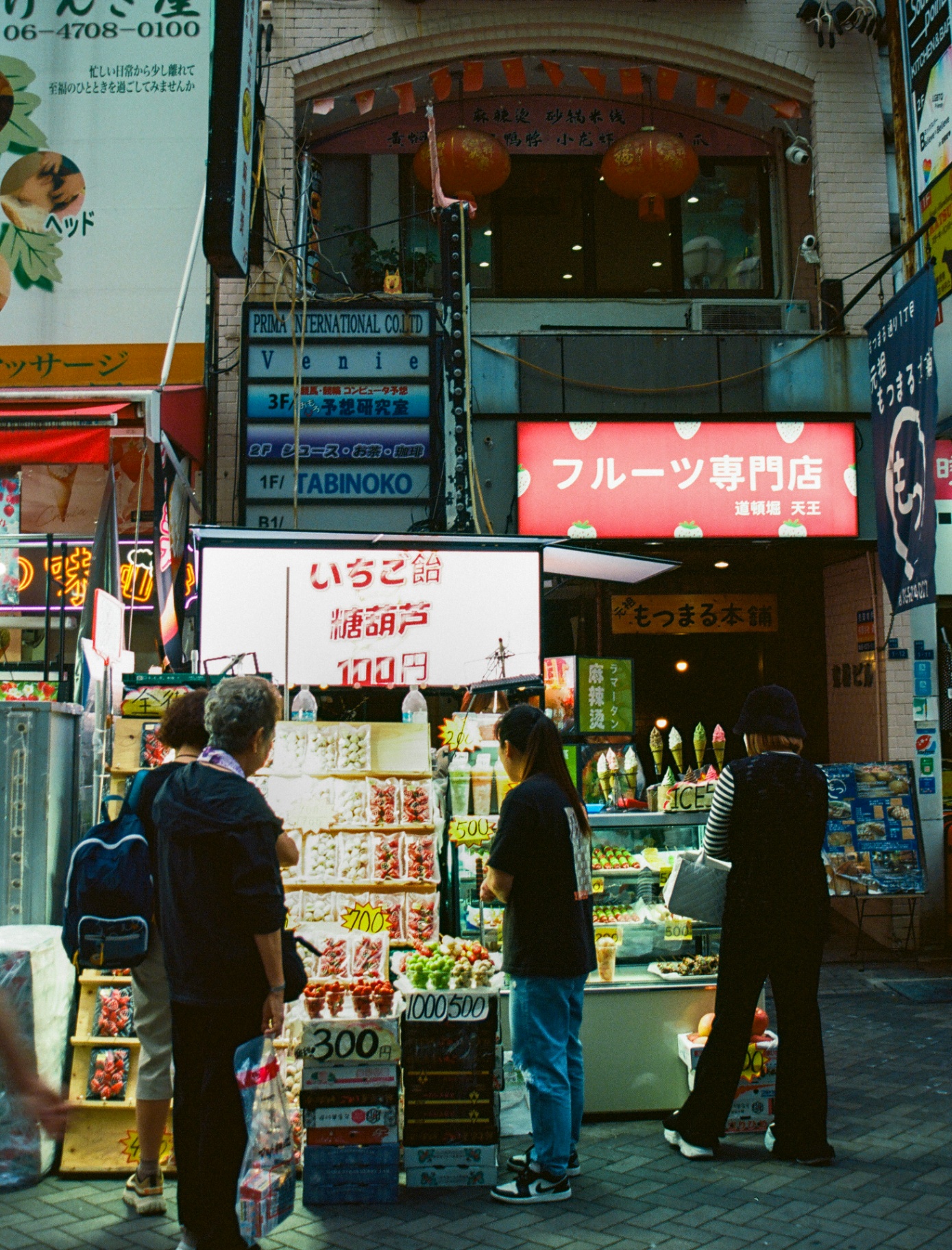 A candied strawberry stand on a busy Dōtonbori street in Osaka