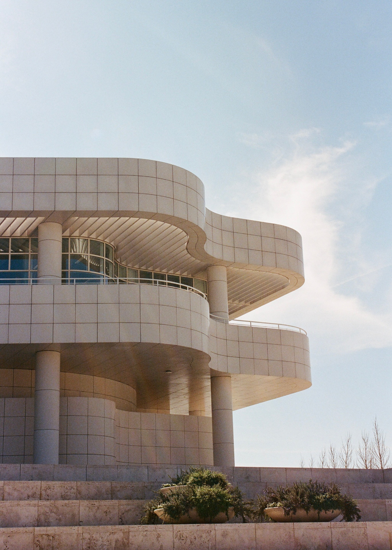 Curved pale stone architecture against a blue sky at the Getty Center in Los Angeles