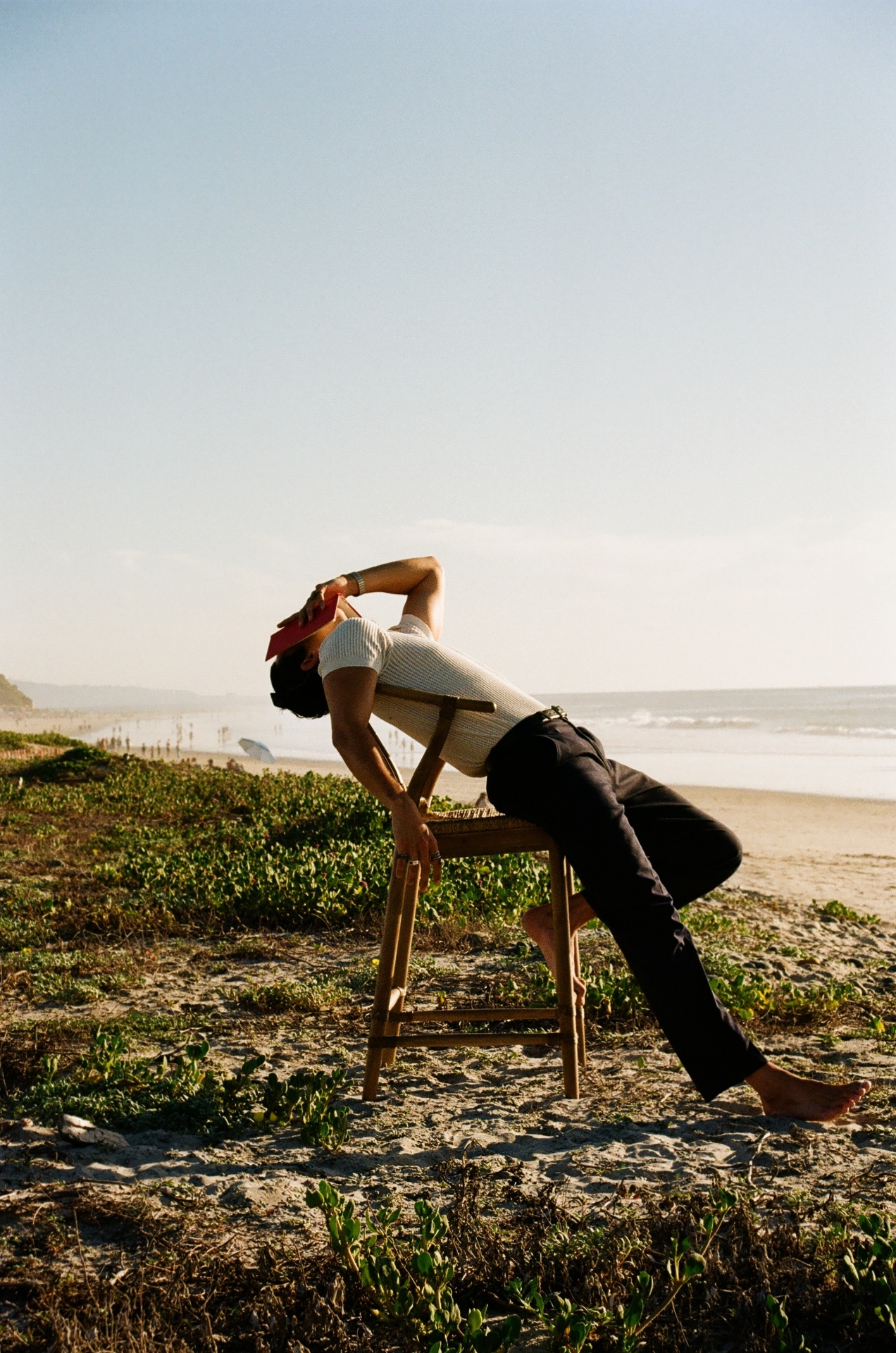 Christian arched back on a chair, ocean behind