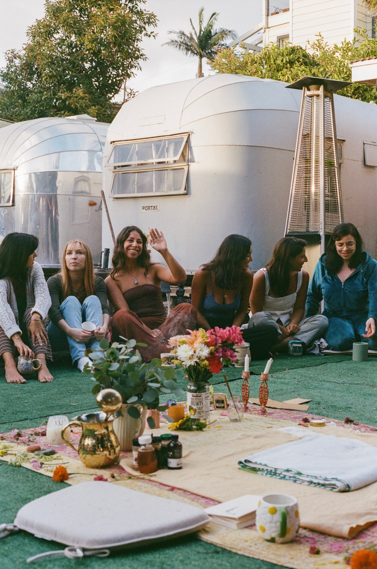 Friends gathered outside the Airstream at golden hour