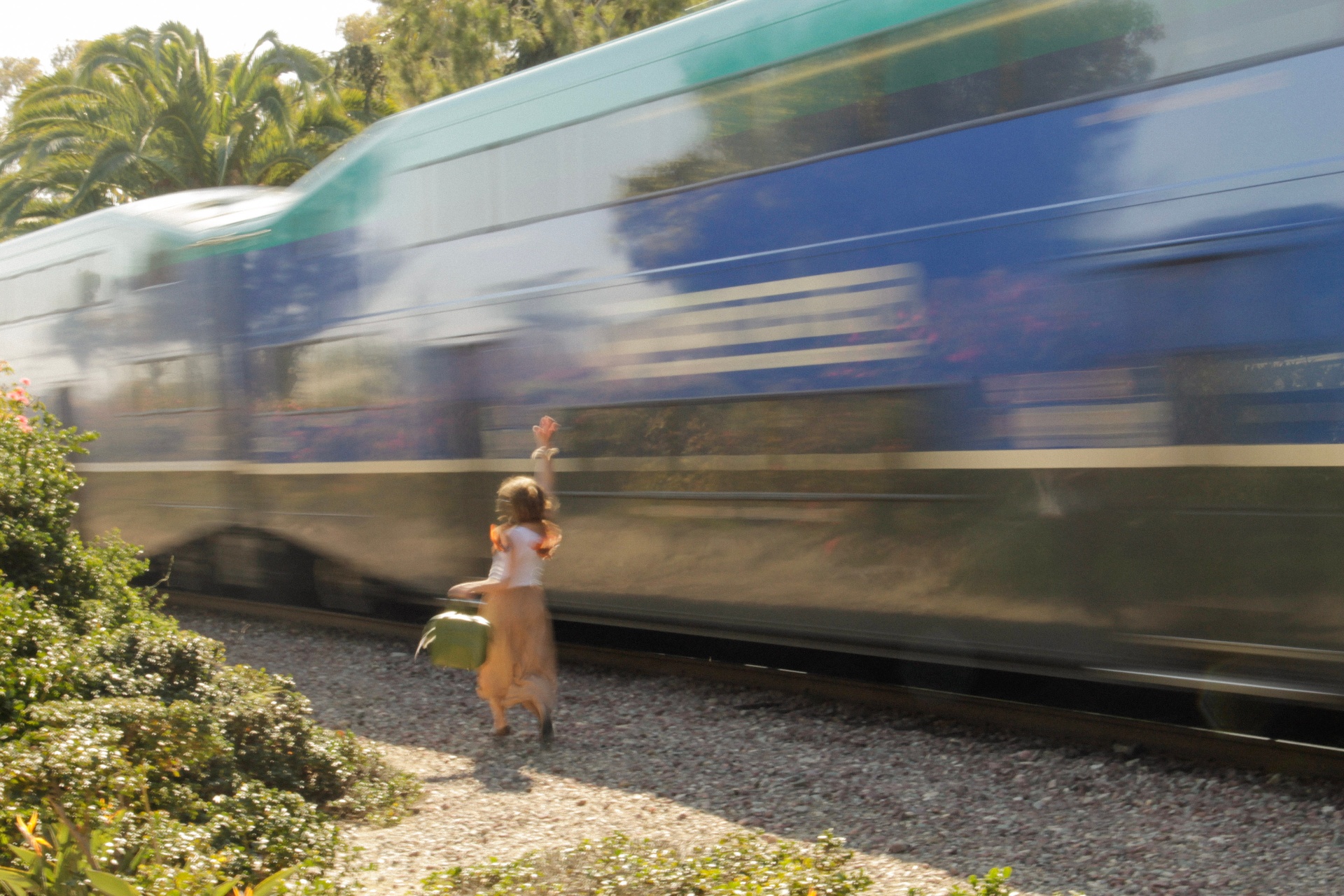 Running alongside the passing train, hand raised